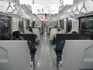 先頭車の車内。E217系と同じセミクロスシートだが、車体幅が小さいため通路もやや狭くなっている。2009年11月28日、千葉駅で撮影。