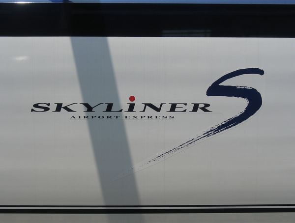 ボディー側面のロゴ。スピード感あふれる筆書きの“S”の文字が大きく描かれている。SKYLiNERの“i”の赤丸は日の丸をイメージしている。新鎌ヶ谷駅にて。