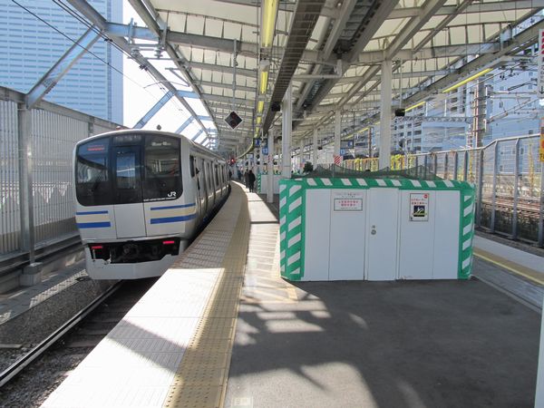 工事中の南武線連絡通路のエスカレータと横須賀線E217系